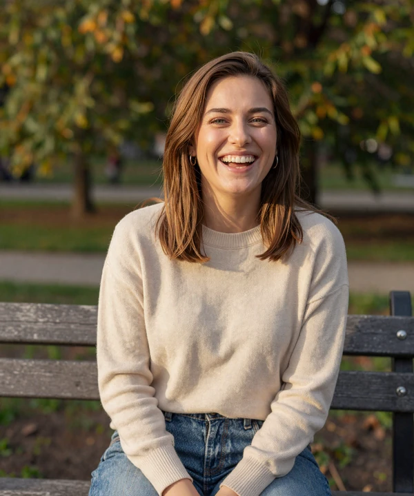 Rachel, 32, laughing on a park bench - a real EvaDate premium subscriber enjoying outdoor dating